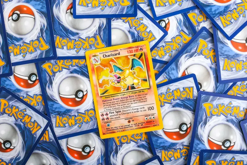 A Base Set Charizard card lying face up on a spread of Pokemon card backs